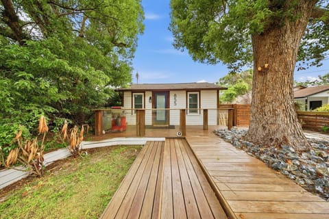 Charming cottage entrance with spacious deck and shady mature trees