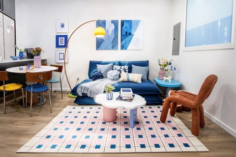 Playful modern lounge with plush sofa, artful decor and dining nook.