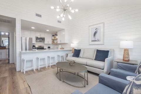 Living Area/Kitchen - This cozy duplex unit is setup to utilize every square inch of space. The open living area flows seamlessly into the kitchen with dining in between  at the open bar. The large mounted television offers entertainment during your down time.