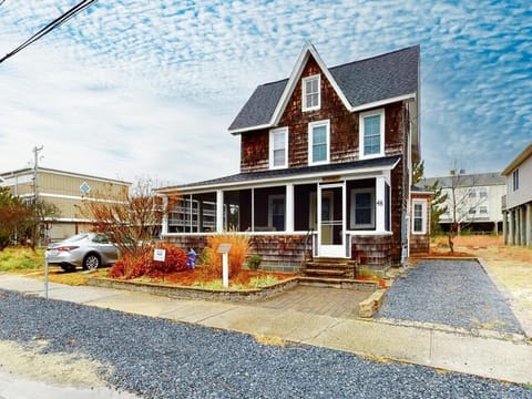 This charming four-bedroom house features a traditional exterior with shingle siding and a welcoming porch, set on a spacious lot in Bethany Beach.