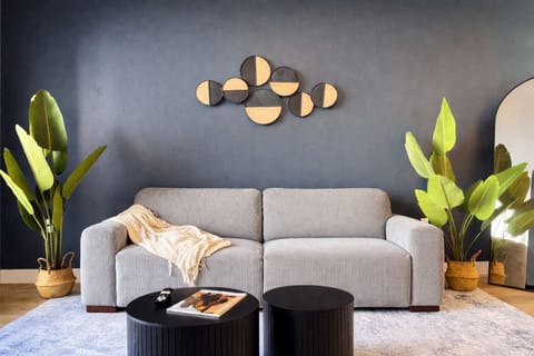 Spacious living room featuring a cozy sofa, a full-size air mattress, and a 65" Smart TV with preloaded access to Netflix, Hulu, and Disney+, all set up for your enjoyment.