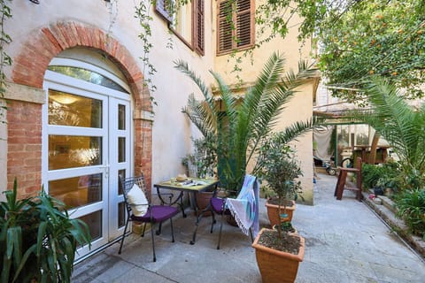 Step into courtyard entrance, a charming oasis in the heart of the Old Town. This lovely front terrace, framed by a classic brick arch and lush greenery, offers a perfect spot to savor your morning coffee and soak in the historic atmosphere before explori