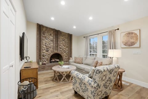 Bright living room with stone fireplace and comfortable seating