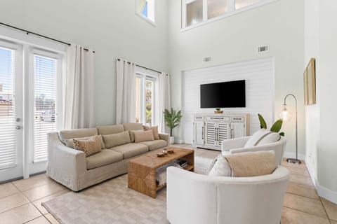 The living room is a bright and welcoming space, highlighted by vaulted ceilings that open up to the second floor and create an airy, expansive feel.