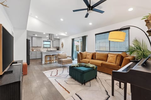 Spacious open-concept living room featuring modern decor and a view of the fully equipped kitchen.