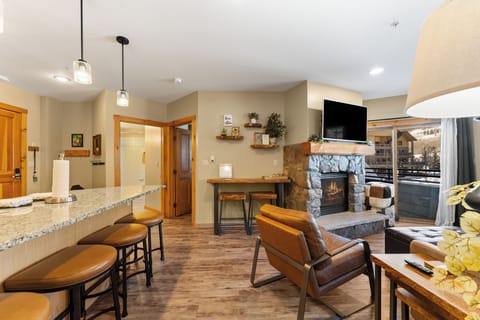 Unwind in your open-concept living space where warm leather seating faces a crackling stone fireplace, while granite countertops invite casual dining.