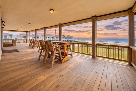 Spacious covered beachfront deck at Crystal Beach TX featuring large picnic table seating and panoramic Gulf views—perfect for outdoor dining and relaxing by the ocean.