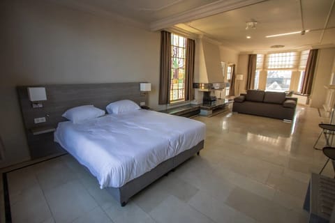 Unwind in a spacious suite with lounge seating and sunlight.