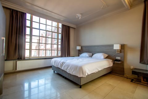 Wake up refreshed in crisp linens beside oversized windows.