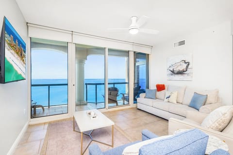 Unwind in your bright living room where floor-to-ceiling windows frame stunning gulf views and soft coastal breezes flow through.