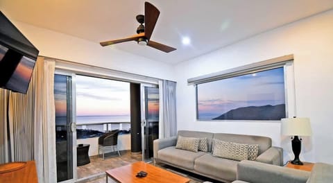 The sitting area offers comfortable sofas, a coffee table, and a wall-mounted TV