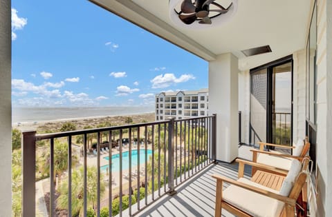 High-angle shot of the pool area and ocean from the private balcony.