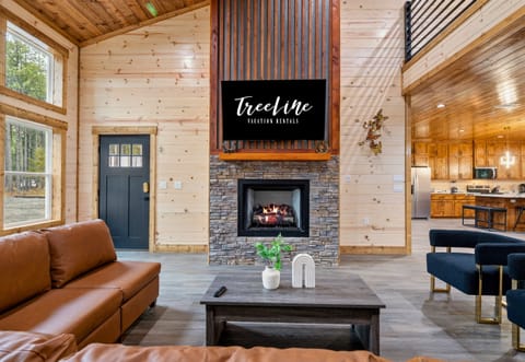 A bright and inviting sitting area near the fireplace offers another comfortable spot to chat, read, or simply enjoy the peaceful cabin atmosphere.