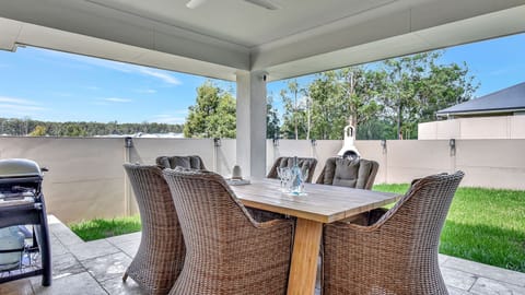 Alfresco dining with BBQ and a view of the lush lawn.