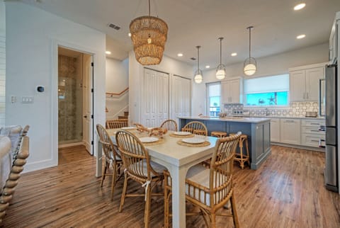 Dining area with a large wooden table, wicker chairs, and a statement chandelier. (Southern Cross)