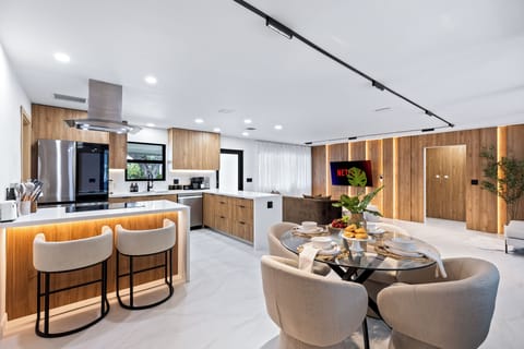 Open-concept kitchen, dining, and living area with a clean modern design.