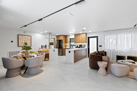 Open-concept kitchen, dining, and living area with a clean modern design.