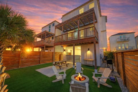 Private fenced backyard with firepit, outdoor seating, and covered patio. (Dune & Done)