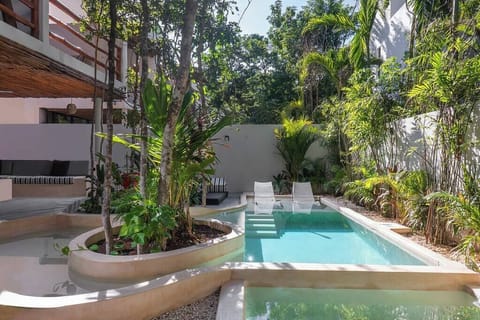 Impressive pool with a unique design located in the villa's courtyard. Natural vegetation surrounds the space.
