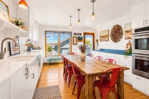 Bright, open kitchen designed for gathering—featuring a large farmhouse table, modern appliances, and plenty of space for shared meals, morning coffee, and late-night card games.