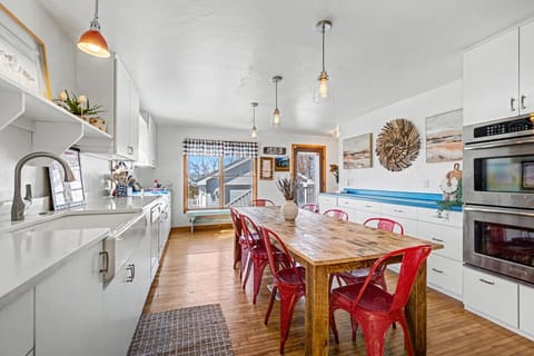 Bright, open kitchen designed for gathering—featuring a large farmhouse table, modern appliances, and plenty of space for shared meals, morning coffee, and late-night card games.