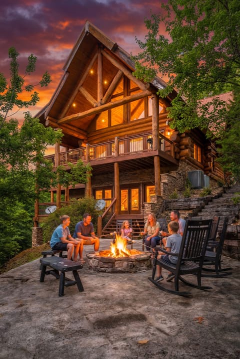Warm up by the fire pit as the sun sets behind this stunning log cabin retreat. 