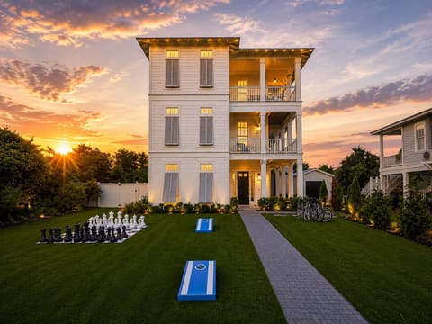Sunset-lit coastal retreat with balconies, lawn games, and bikes