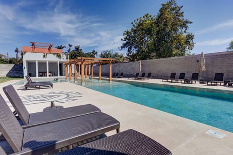Shared resort-style pool w/ loungers & umbrellas for laid-back sun-soaked afternoons