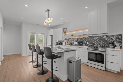 Fully equipped modern kitchen with sleek finishes, stainless steel appliances, and a gas stove.
