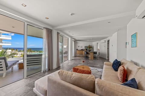 Bright open living area with floor-to-ceiling windows and ocean views—blending indoor comfort with breathtaking coastal scenery.