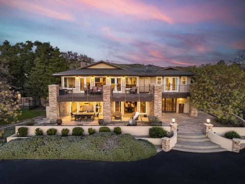 Stunning twilight view of the main residence with warm interior lighting.