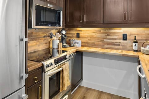 Enjoy preparing meals in this stylish and functional kitchen with rich cabinetry and spacious butcher-block countertops.
