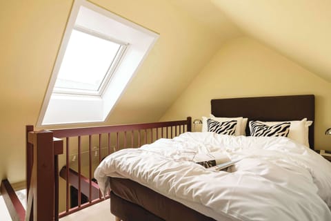 Relax under the skylight in this bright loft bedroom filled with natural light.