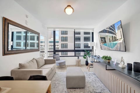 Bright and modern living area with large windows, city views, and a cozy, stylish setup perfect for relaxing.