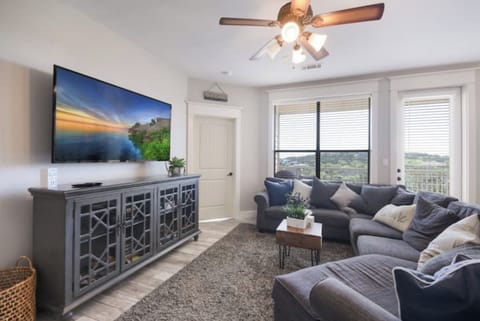 Bright living room with comfortable seating, smart TV, and large windows overlooking the Hill Country near Lake Travis