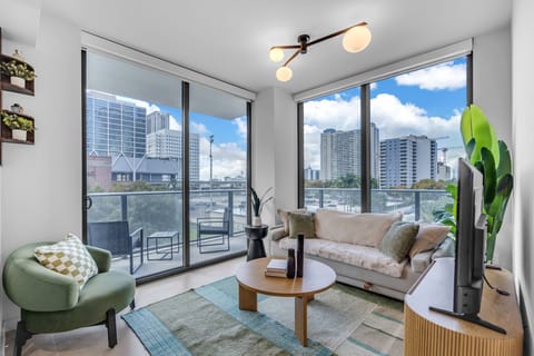 Floor-to-ceiling views and chic urban style! This light-filled living area features modern design, a private balcony, and a cozy atmosphere perfect for city living. Enjoy the best of comfort and sophistication in this bright designer space.