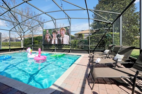 Enjoy a unique outdoor experience with a poolside movie setup, perfect for relaxing swims.