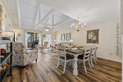 The vaulted ceilings with exposed beams give the room an open coastal feel, while the warm wood floors and beach-inspired décor make the space feel instantly relaxing.