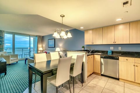 Modern dining and kitchen area with elegant flooring, sleek furniture,