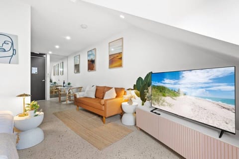 Bright open-plan lounge with modern styling, smart TV, and comfortable seating for unwinding.