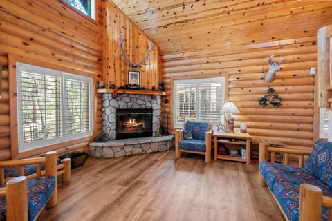 Living Room - The living space is inviting and comfortable, complete with a wood-burning fireplace, comfy seating, and vaulted ceilings.