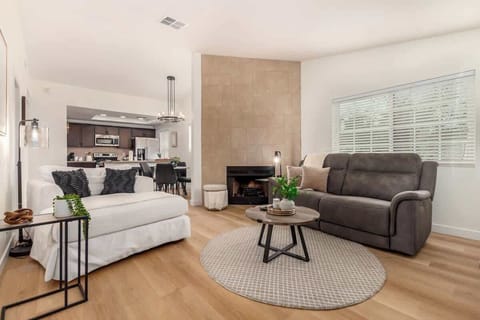 Relax in the living room with a reclining loveseat and a decorative fireplace, creating the perfect space for comfort and warmth.