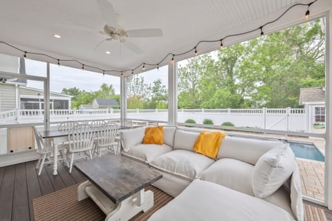 Enjoy sunset views from the inviting screened porch, with plush seating and a rustic dining table.