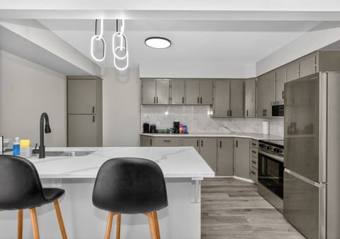 Bright modern kitchen with quartz island, stainless steel appliances, and plenty of space to cook and gather.