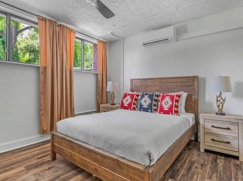 Enjoy a spacious, stylish bedroom in Asheville featuring a queen bed, contemporary décor, and abundant natural light.