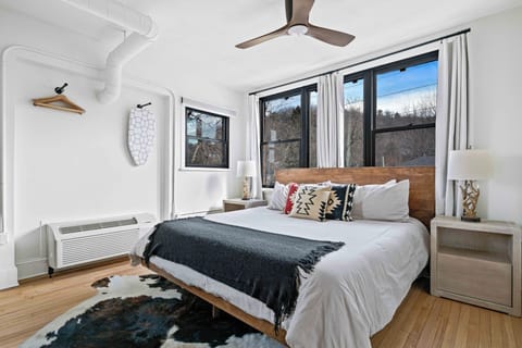 Enjoy a spacious, stylish bedroom in Asheville featuring a king bed, contemporary décor, and abundant natural light.