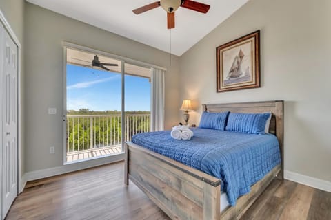 Bedroom with waterfront balcony views and queen bed