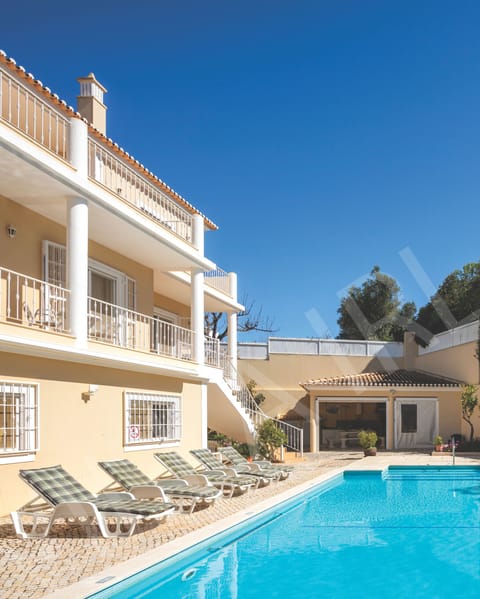 View of the rear of Villa Irlandais, showing multi-level balconies, terraces and outdoor living spaces.