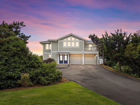 This elegant coastal retreat sits beautifully among mature trees with a stunning twilight sky painting the perfect backdrop for your getaway arrival.
