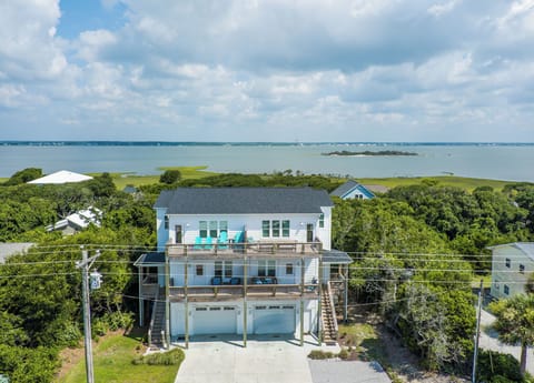 Elevated coastal home with stunning water views and multiple decks in a peaceful wooded setting.
